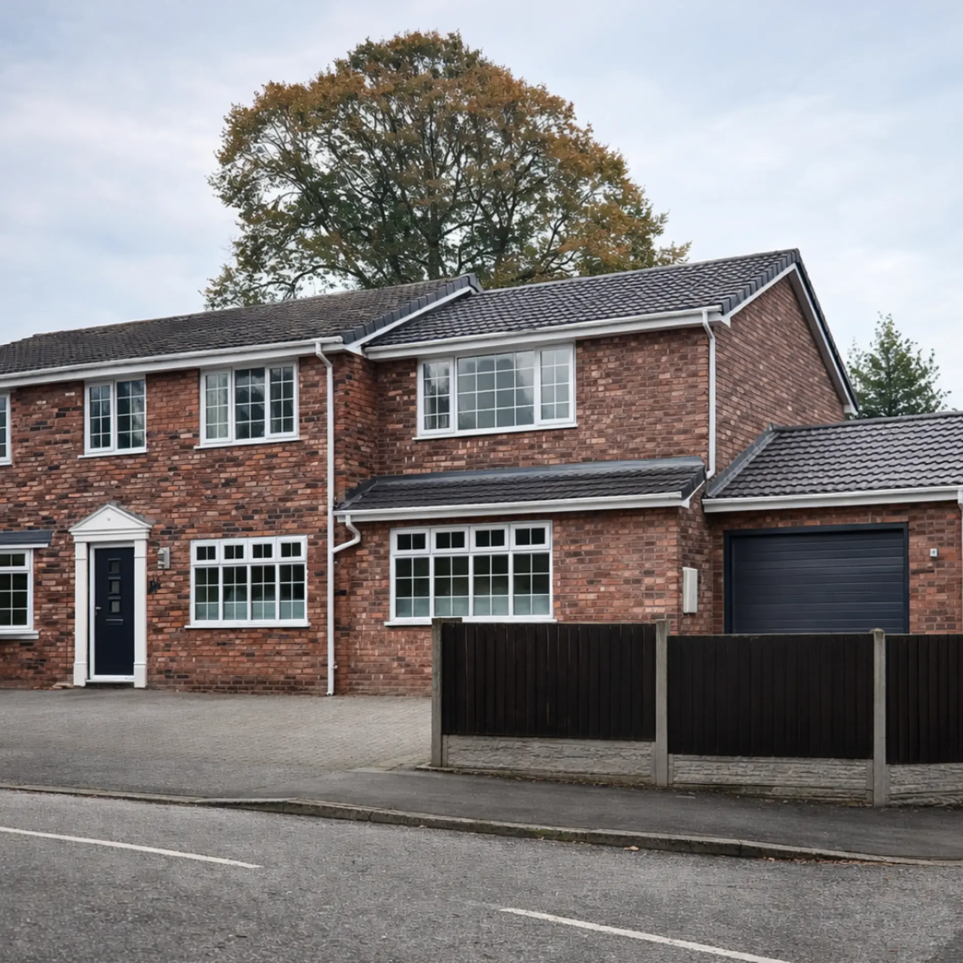 Completed large two-storey red-brick extension with integrated garage in Stone