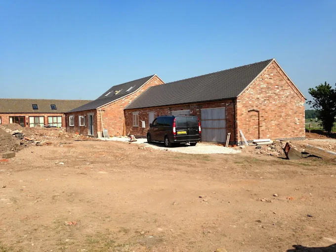 Completed brick barn conversion exterior with gravel driveway, Staffordshire
