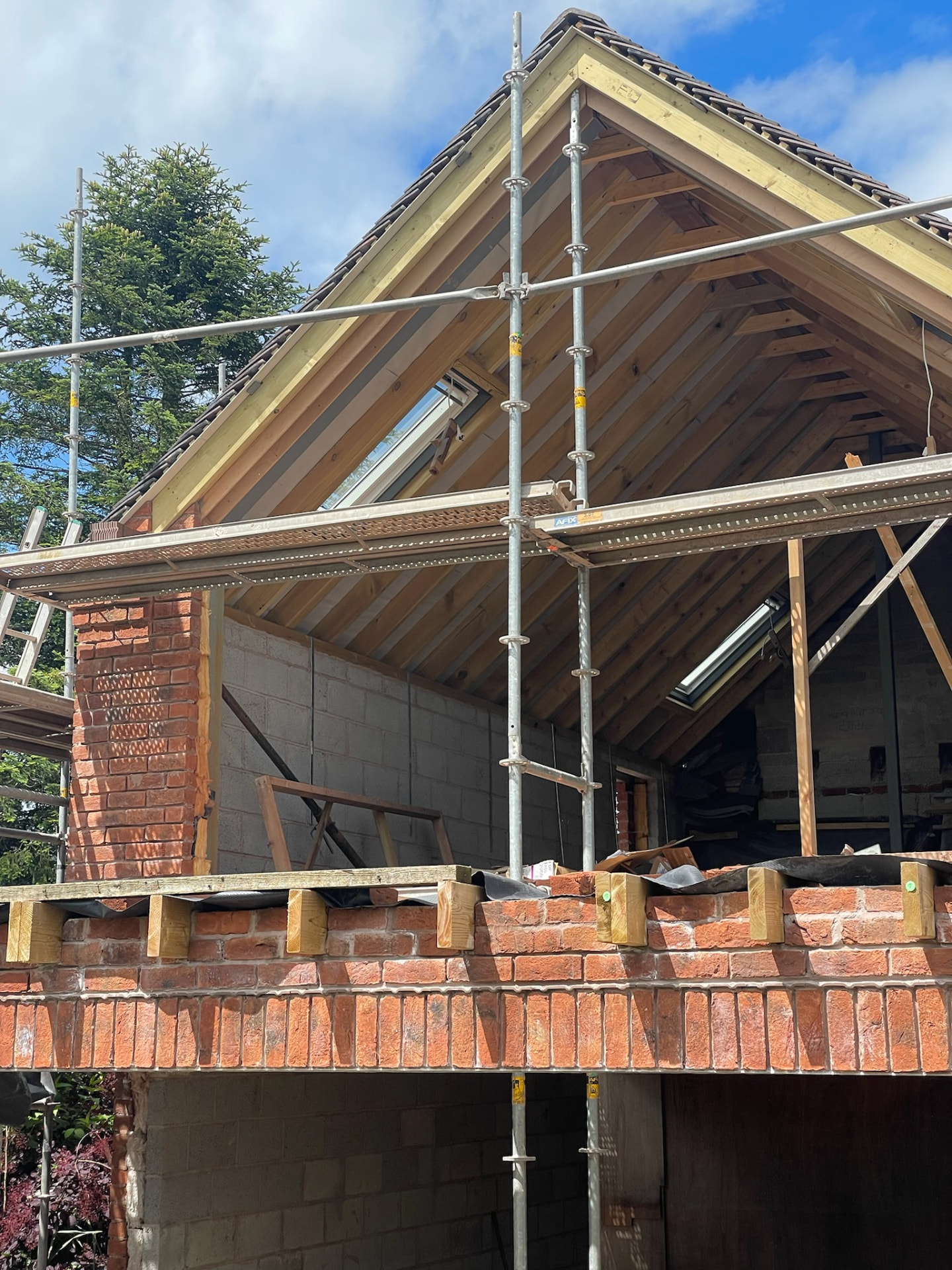 Two-storey apex extension under construction in Penkridge with new roof timbers and scaffolding