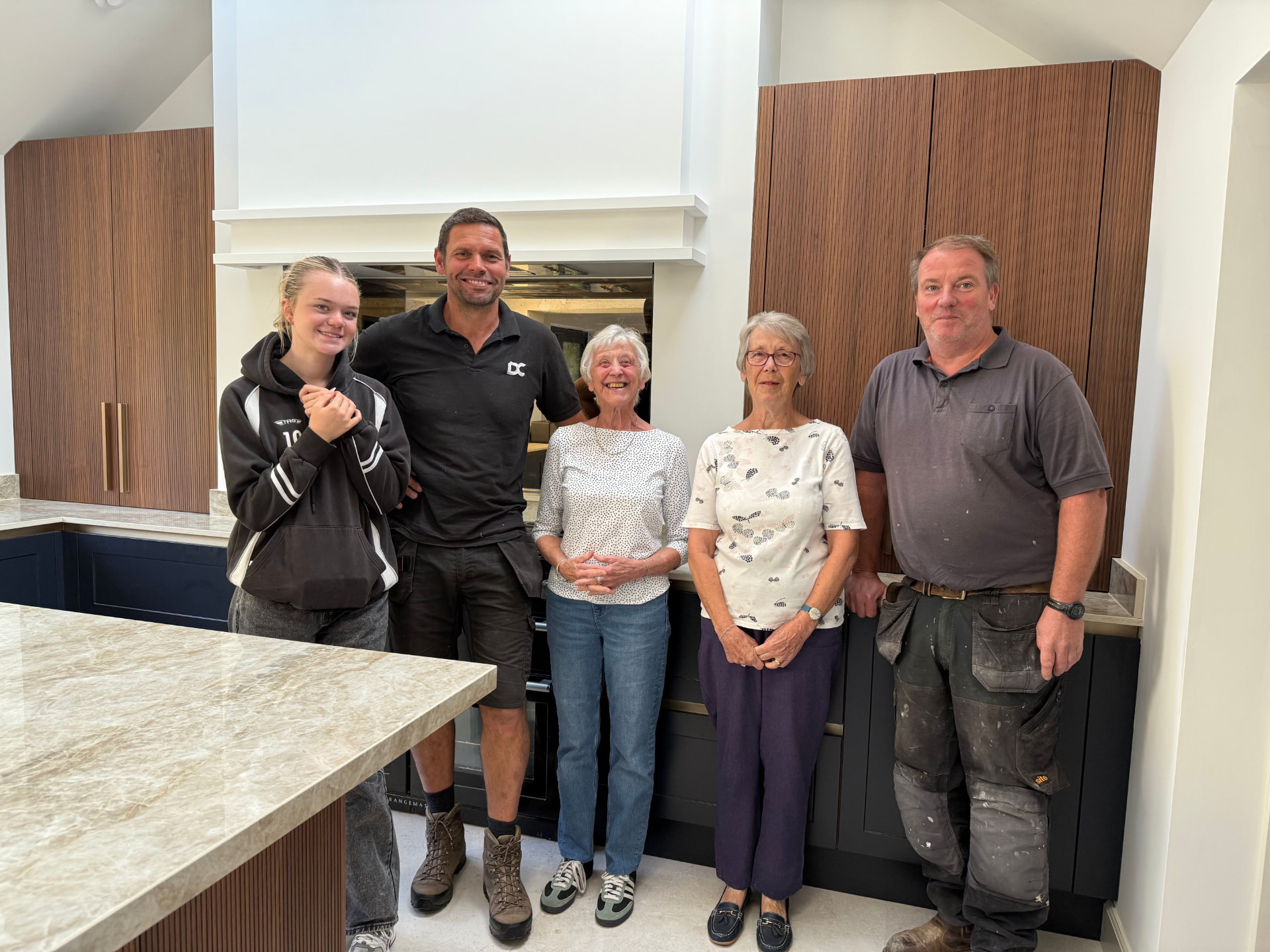 The Dixon Construction team with happy clients in a finished kitchen